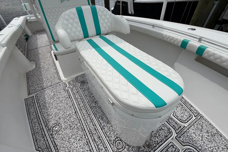 Slide: The Image of 2002 Yellowfin 31 Center Console boat with teal and white cushioned seating. - 38