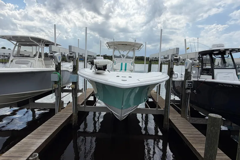 Slide: The Image of 2002 Yellowfin 31 Center Console boat docked between two others under a cloudy sky. - 6