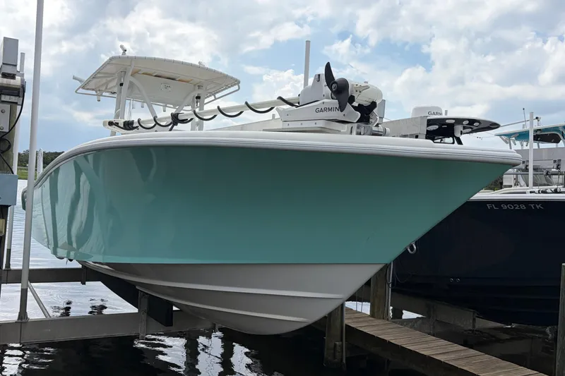 Slide: The Image of 2002 Yellowfin 31 Center Console boat docked, featuring a sleek turquoise hull and Garmin equipment. - 8