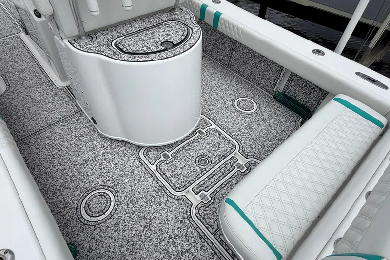 Slide: The Image of 2002 Yellowfin 31 Center Console boat interior with textured flooring and cushioned seating. - 13