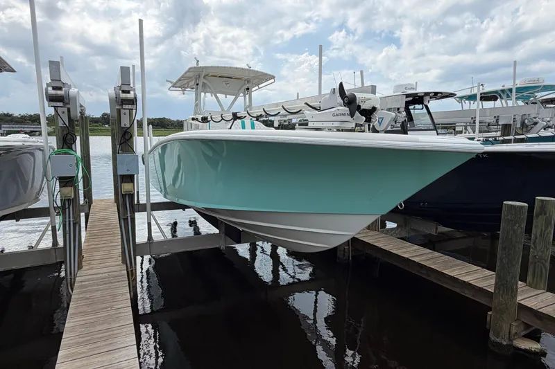 Slide: The Image of 2002 Yellowfin 31 Center Console boat docked, featuring a sleek turquoise hull. - 5