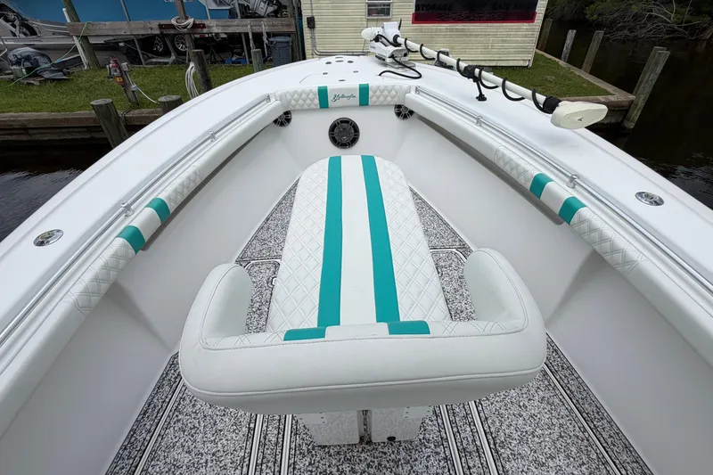Slide: The Image of 2002 Yellowfin 31 Center Console boat interior with teal accents and cushioned seating. - 28