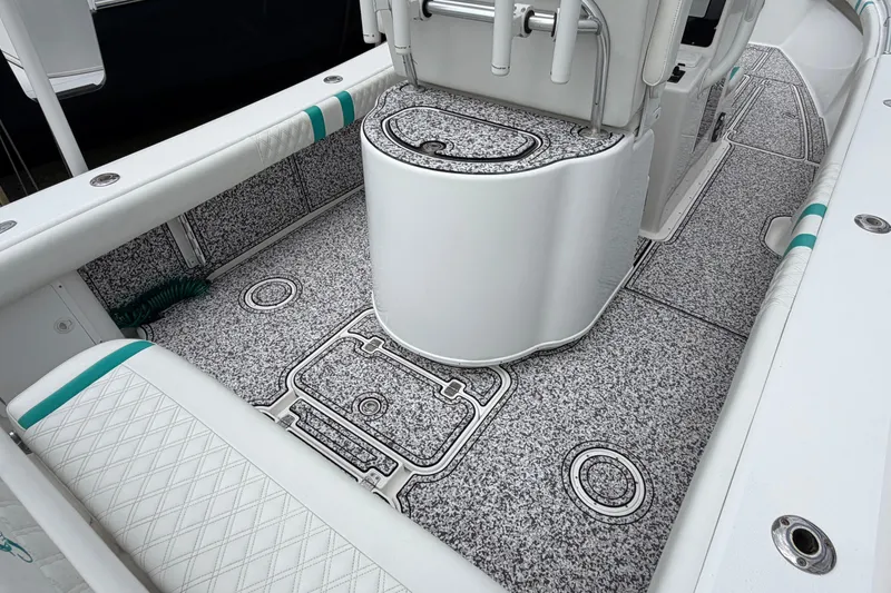 Slide: The Image of 2002 Yellowfin 31 Center Console boat interior with textured flooring and cushioned seating. - 14