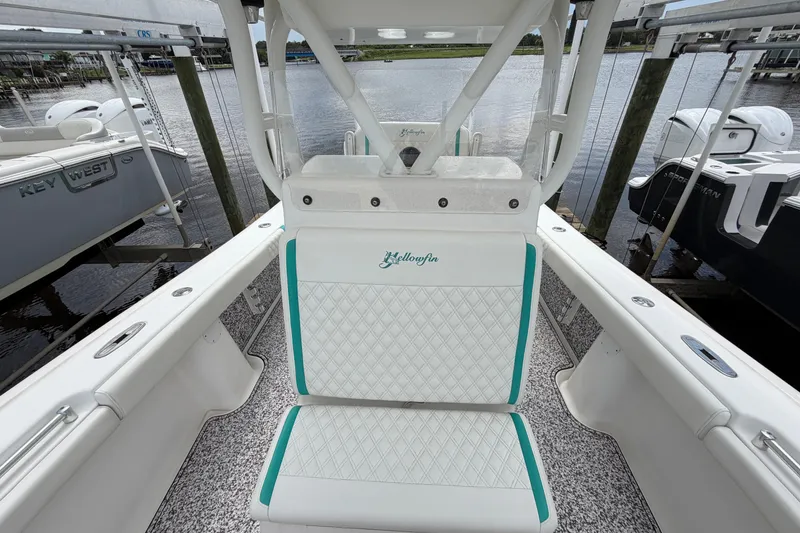 Slide: The Image of 2002 Yellowfin 31 Center Console boat interior with white and teal seating, docked by the water. - 41