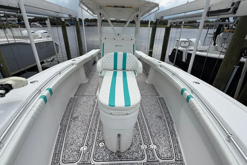Slide: The Image of 2002 Yellowfin 31 Center Console boat with teal accents docked by the water. - 36
