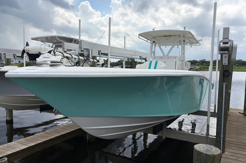 Slide: The Image of 2002 Yellowfin 31 Center Console boat docked, featuring a sleek turquoise hull and modern equipment. - 1