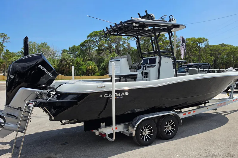 Slide: The Image of 2025 Caymas 281 HB boat on trailer, featuring sleek black design and Mercury engine. - 5