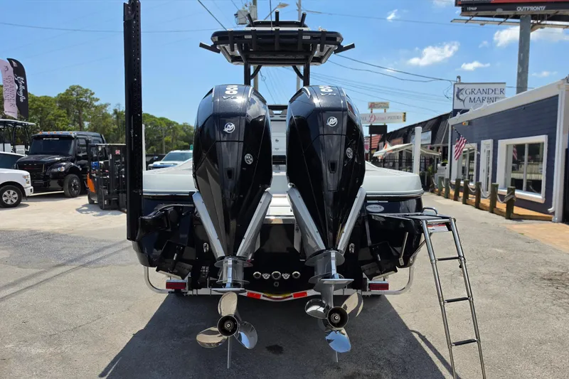 Slide: The Image of 2025 Caymas 281 HB boat with dual outboard engines, parked at a marina. - 4