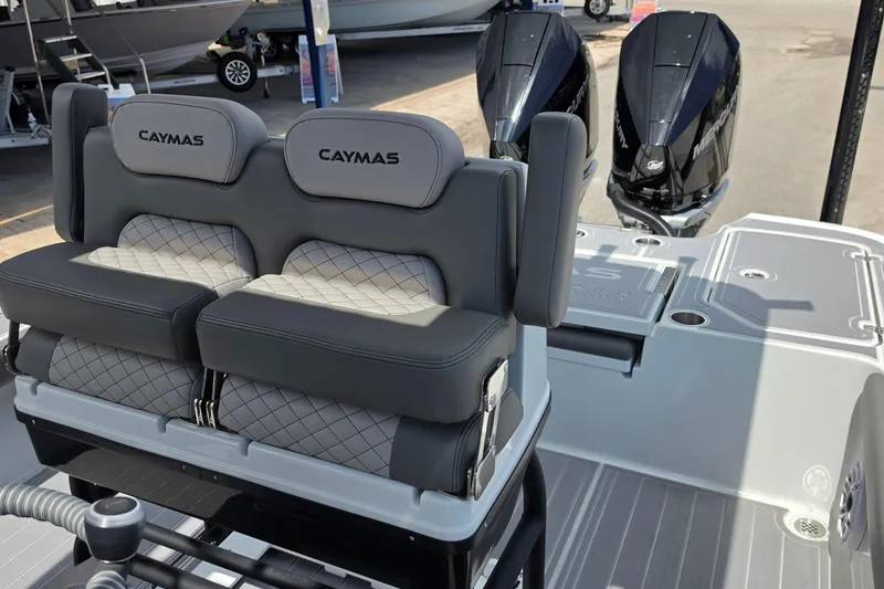 Slide: The Image of 2025 Caymas 281 HB boat interior with dual Mercury engines and cushioned seating. - 12