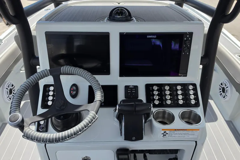 Slide: The Image of 2025 Caymas 281 HB boat dashboard with steering wheel, controls, and Simrad display. - 11