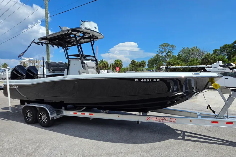 Slide: The Image of 2025 Caymas 281 HB boat on trailer, parked outdoors under clear blue sky. - 7