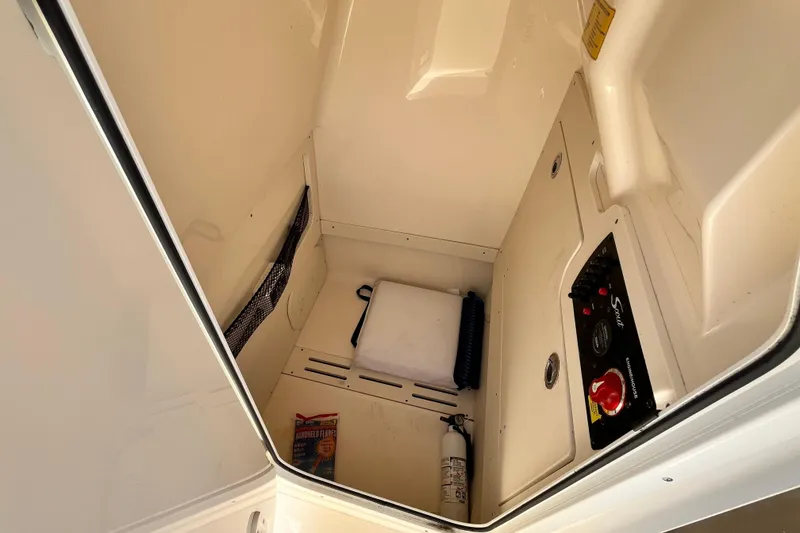 Slide: The Image of Interior storage compartment of 2021 Scout 215 XSF boat with safety equipment. - 29