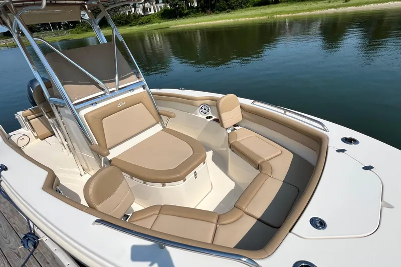 Slide: The Image of 2021 Scout 215 XSF boat with tan seating, docked by a serene lake. - 22