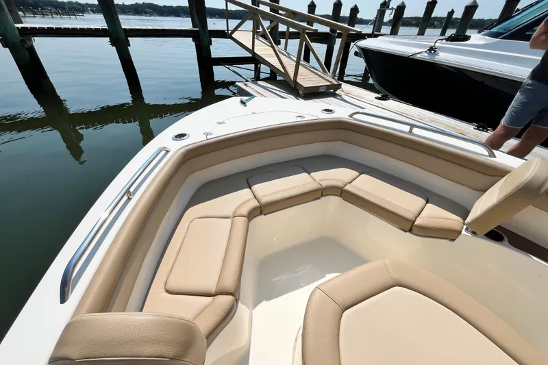 Slide: The Image of 2021 Scout 215 XSF boat with beige seating, docked by a wooden pier. - 24