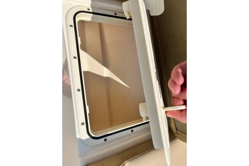 Slide: The Image of Open hatch on 2021 Scout 215 XSF boat, showcasing interior compartment. - 31
