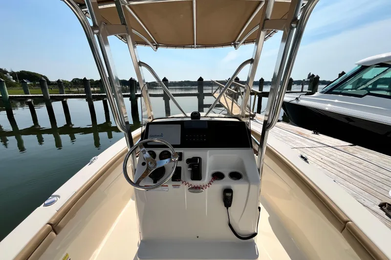 Slide: The Image of 2021 Scout 215 XSF boat helm with Garmin navigation, docked by calm waters. - 17