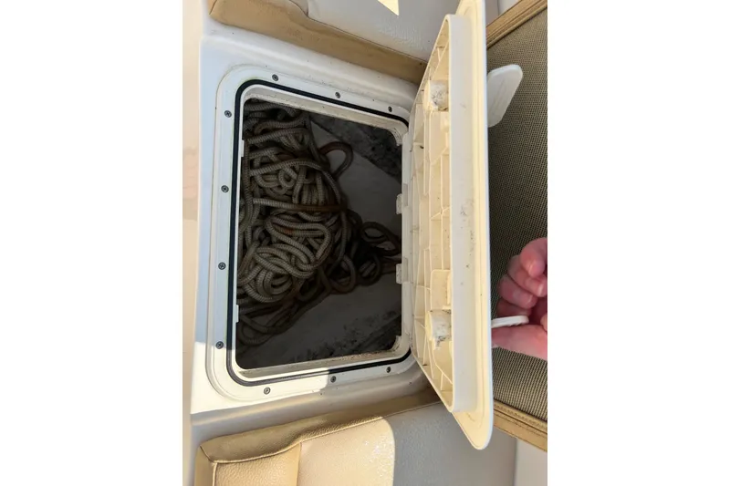 Slide: The Image of Storage compartment with coiled rope on a 2021 Scout 215 XSF boat. - 32