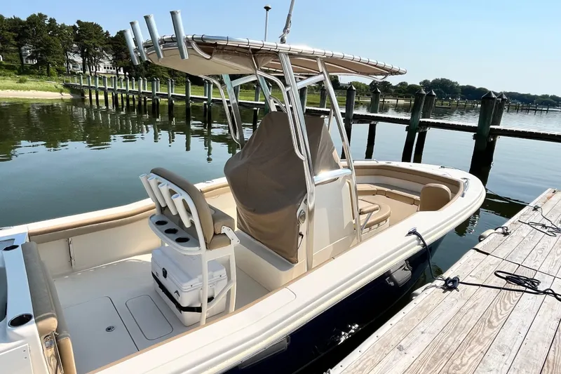 Slide: The Image of 2021 Scout 215 XSF boat docked by a serene waterfront. - 7
