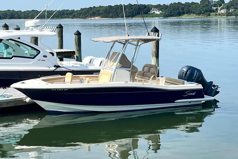 The Image of A 2021 Scout 215 XSF boat is docked on calm water. - 0