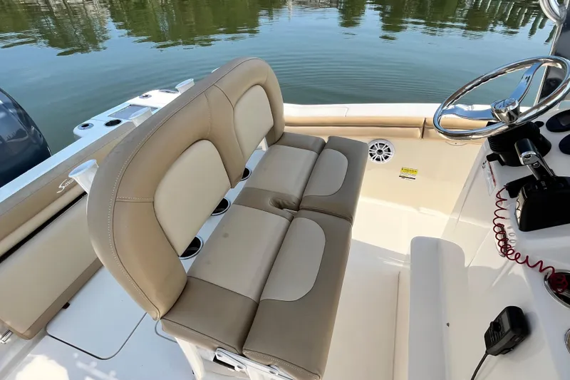 Slide: The Image of 2021 Scout 215 XSF boat interior with beige seating and steering wheel. - 16