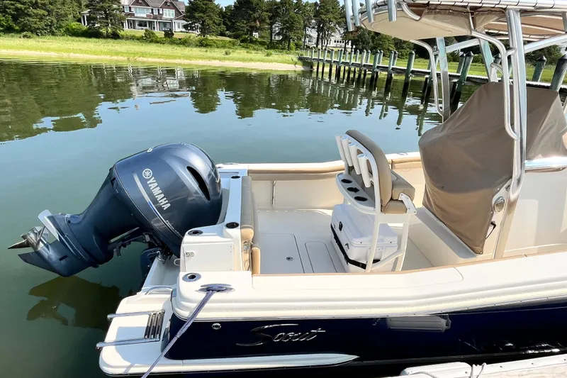 Slide: The Image of 2021 Scout 215 XSF boat with Yamaha outboard motor docked on calm water. - 9