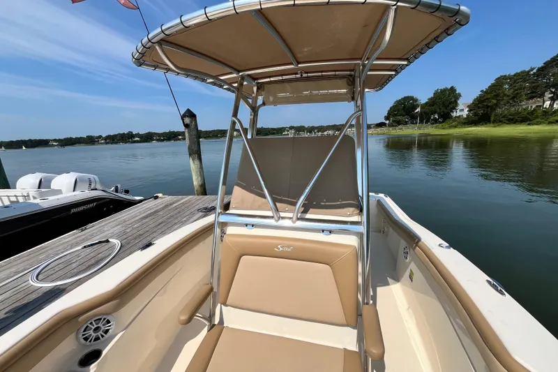 Slide: The Image of 2021 Scout 215 XSF boat docked by serene lake with clear blue sky. - 26