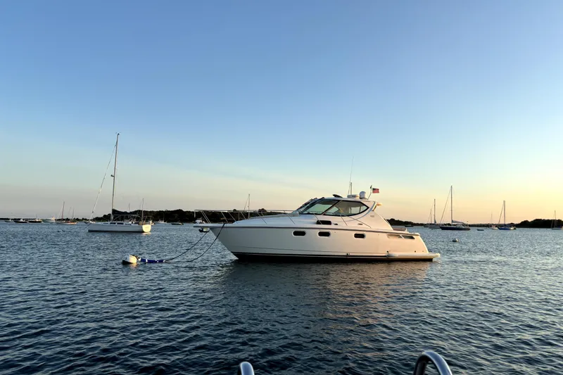 Slide: The Image of 2012 Tiara Yachts 3900 Sovran on calm water at sunset, surrounded by sailboats. - 5