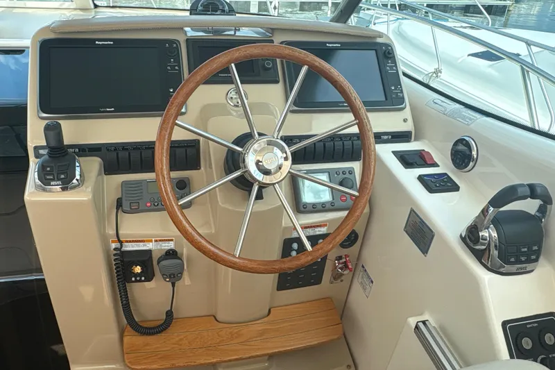 Slide: The Image of Helm of 2012 Tiara Yachts 3900 Sovran with wooden steering wheel and modern controls. - 14