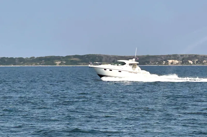 Slide: The Image of 2012 Tiara Yachts 3900 Sovran cruising on open water near a scenic coastline. - 7