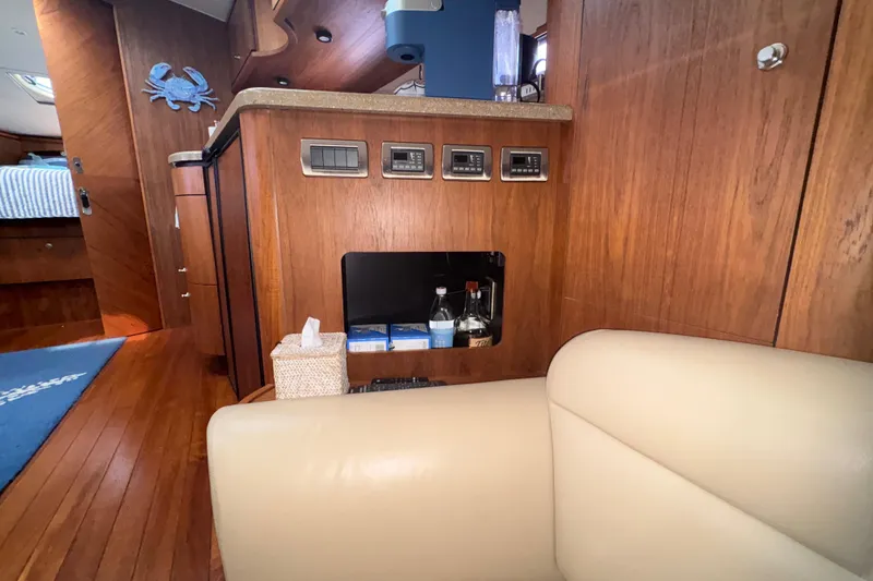Slide: The Image of Interior of 2012 Tiara Yachts 3900 Sovran, featuring wood paneling and a cozy seating area. - 38
