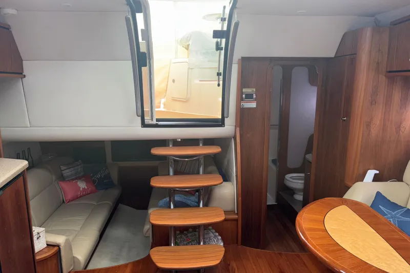 Slide: The Image of Interior of 2012 Tiara Yachts 3900 Sovran, featuring wooden stairs and cozy seating area. - 43
