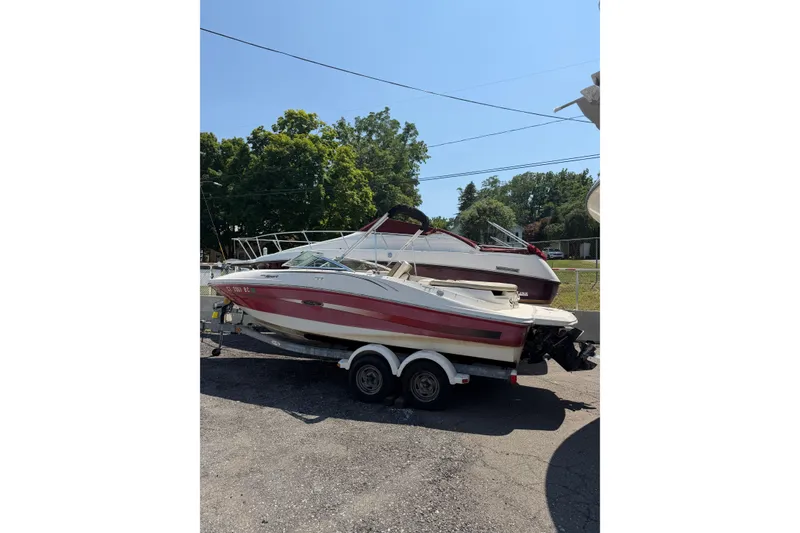 Slide: The Image of 2006 Sea Ray 195 Sport boat on trailer, parked outdoors under clear sky. - 3