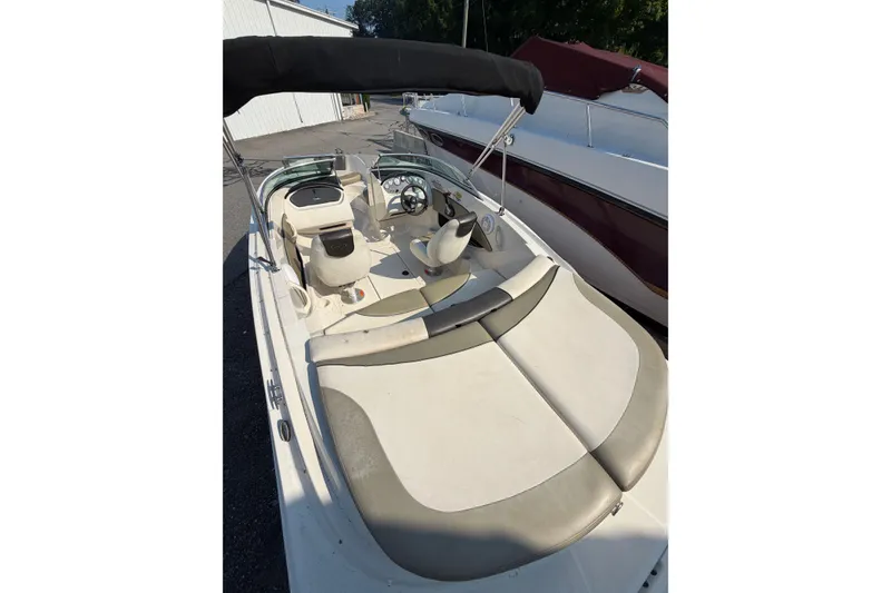 Slide: The Image of 2006 Sea Ray 195 Sport boat interior with seating and steering wheel, under a black canopy. - 6