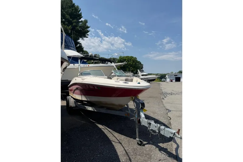 Slide: The Image of 2006 Sea Ray 195 Sport boat on trailer, parked outdoors under clear sky. - 2