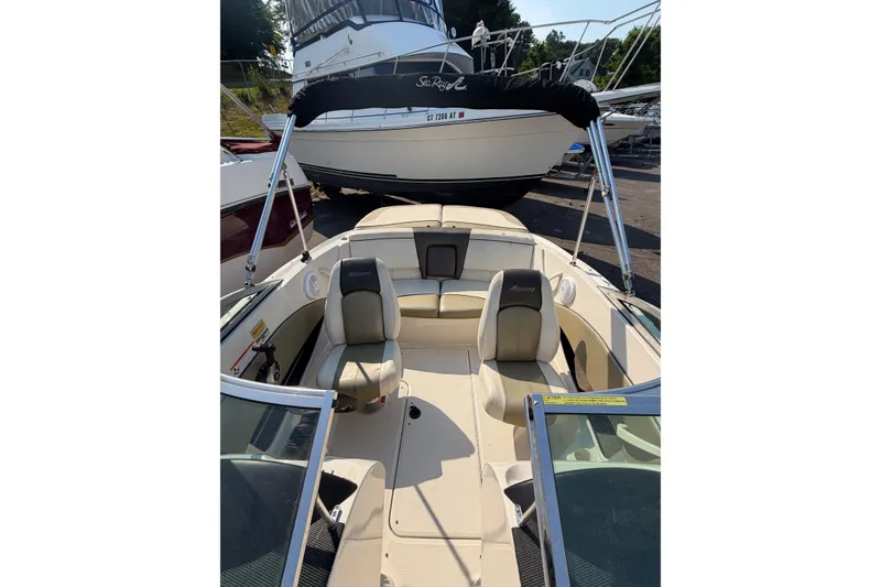 Slide: The Image of 2006 Sea Ray 195 Sport boat interior with seating and steering wheel, parked in marina. - 9