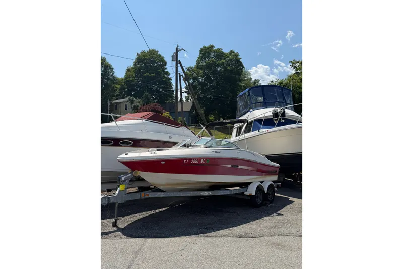 The Image of 2006 Sea Ray 195 Sport boat on trailer, parked outdoors under clear sky. - 0
