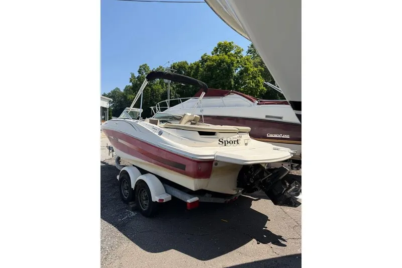 Slide: The Image of 2006 Sea Ray 195 Sport boat on trailer, parked outdoors, with trees in the background. - 4