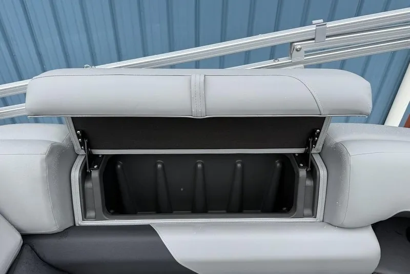 Slide: The Image of Sun Tracker Party Barge 22 DLX 2026 storage compartment with open seat lid. - 29