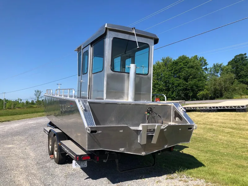 Slide: The Image of A modern workboat with an aluminum hull sits on a trailer in a grassy area. - 3