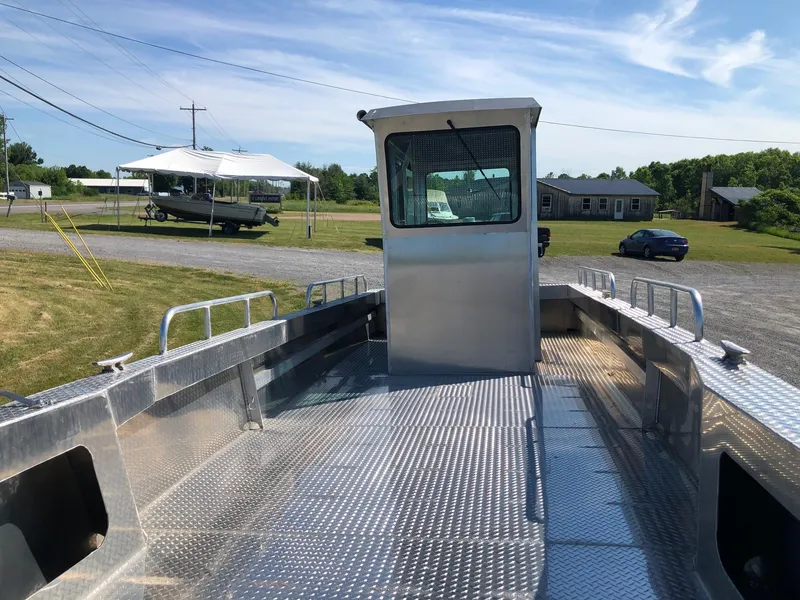 Slide: The Image of A sturdy workboat with an aluminum deck and cabin, parked on dry land. - 6