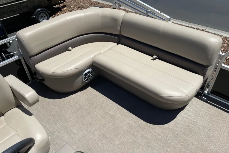 Slide: The Image of 2025 Sun Tracker Party Barge 16 DLX interior with beige seating and speaker system. - 10