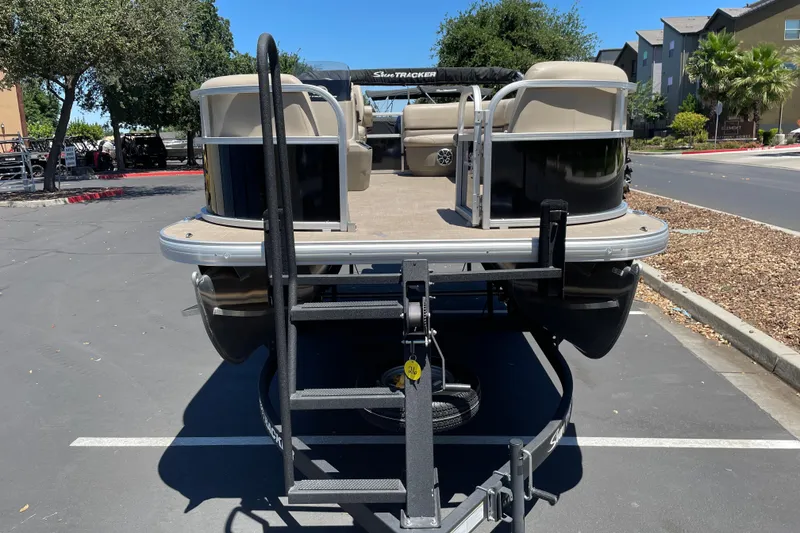 Slide: The Image of 2025 Sun Tracker Party Barge 16 DLX pontoon boat on trailer in parking lot. - 3