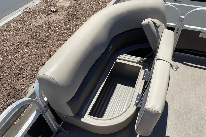Slide: The Image of 2025 Sun Tracker Party Barge 16 DLX with open storage compartment and beige seating. - 6