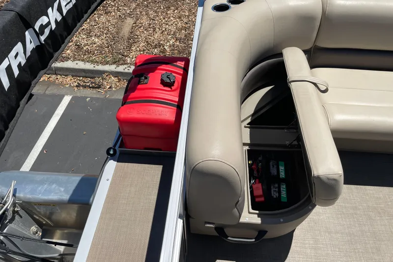 Slide: The Image of 2025 Sun Tracker Party Barge 16 DLX with storage compartment and red fuel tank. - 12