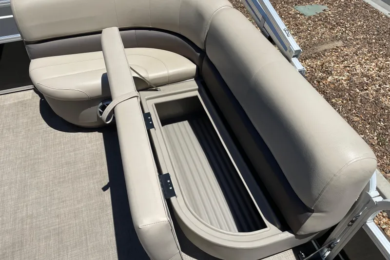 Slide: The Image of 2025 Sun Tracker Party Barge 16 DLX with open storage compartment under beige seating. - 11