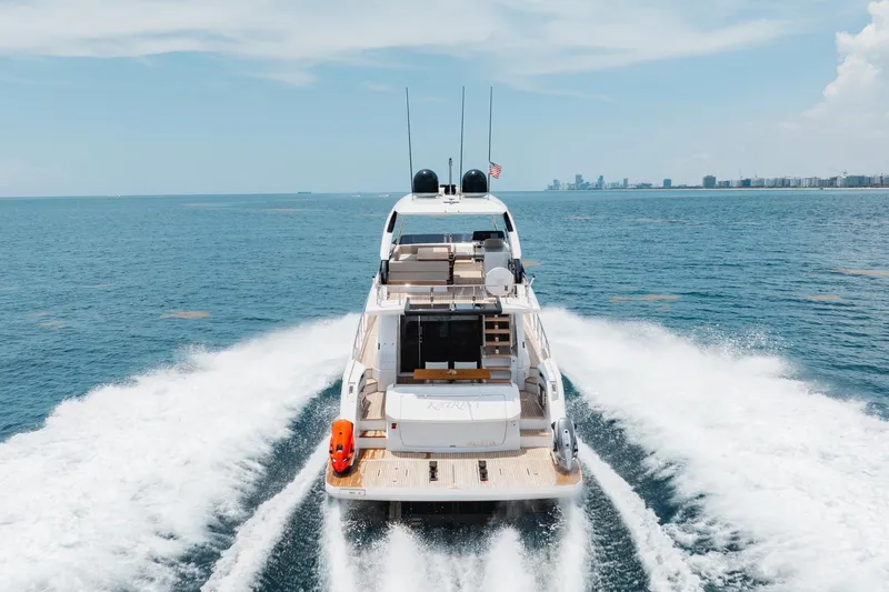 Slide: The Image of 2025 Ferretti Yachts 670 cruising on open sea, city skyline in background. - 36