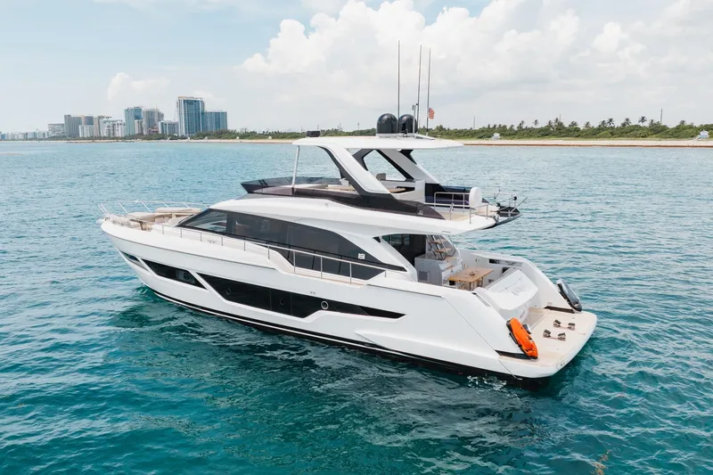 Slide: The Image of 2025 Ferretti Yachts 670 cruising on blue ocean near city skyline. - 39