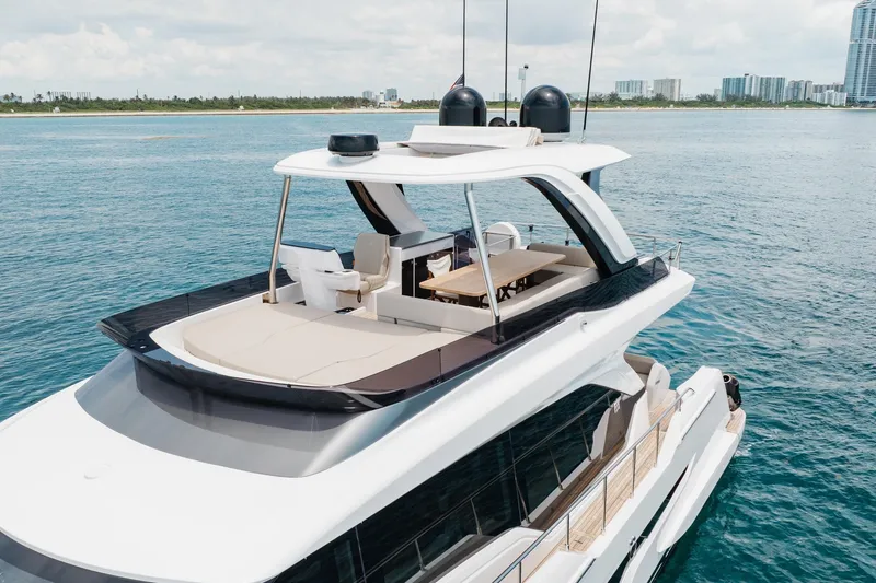Slide: The Image of Luxurious 2025 Ferretti Yachts 670 cruising on serene blue waters near a city skyline. - 29