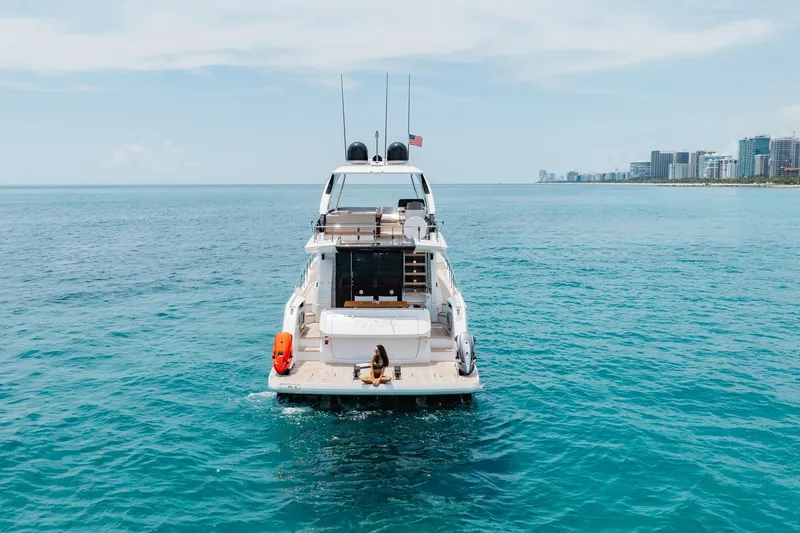 Slide: The Image of 2025 Ferretti Yachts 670 cruising on clear blue ocean near city skyline. - 37