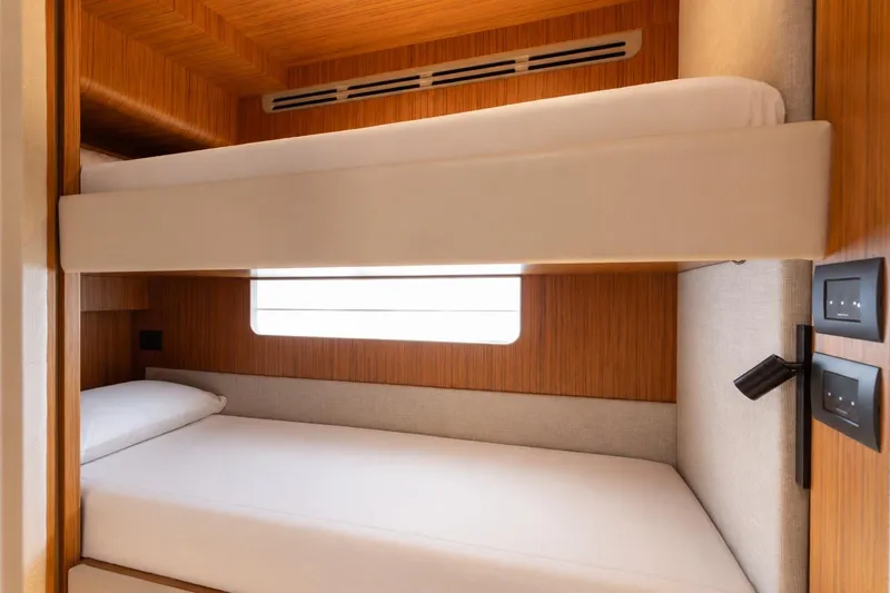 Slide: The Image of 2025 Ferretti Yachts 670 cabin with modern bunk beds and wooden interior design. - 24